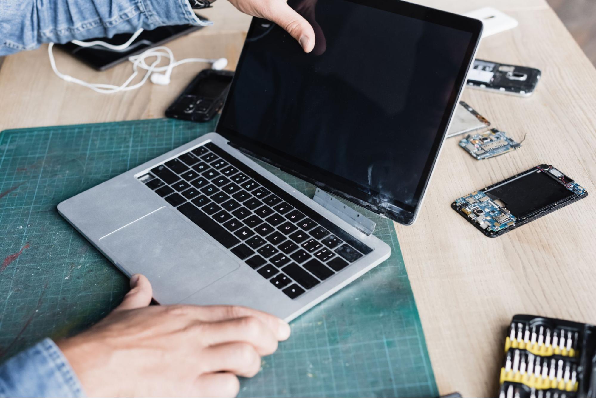 A professional repairing on a MacBook screen replacement.