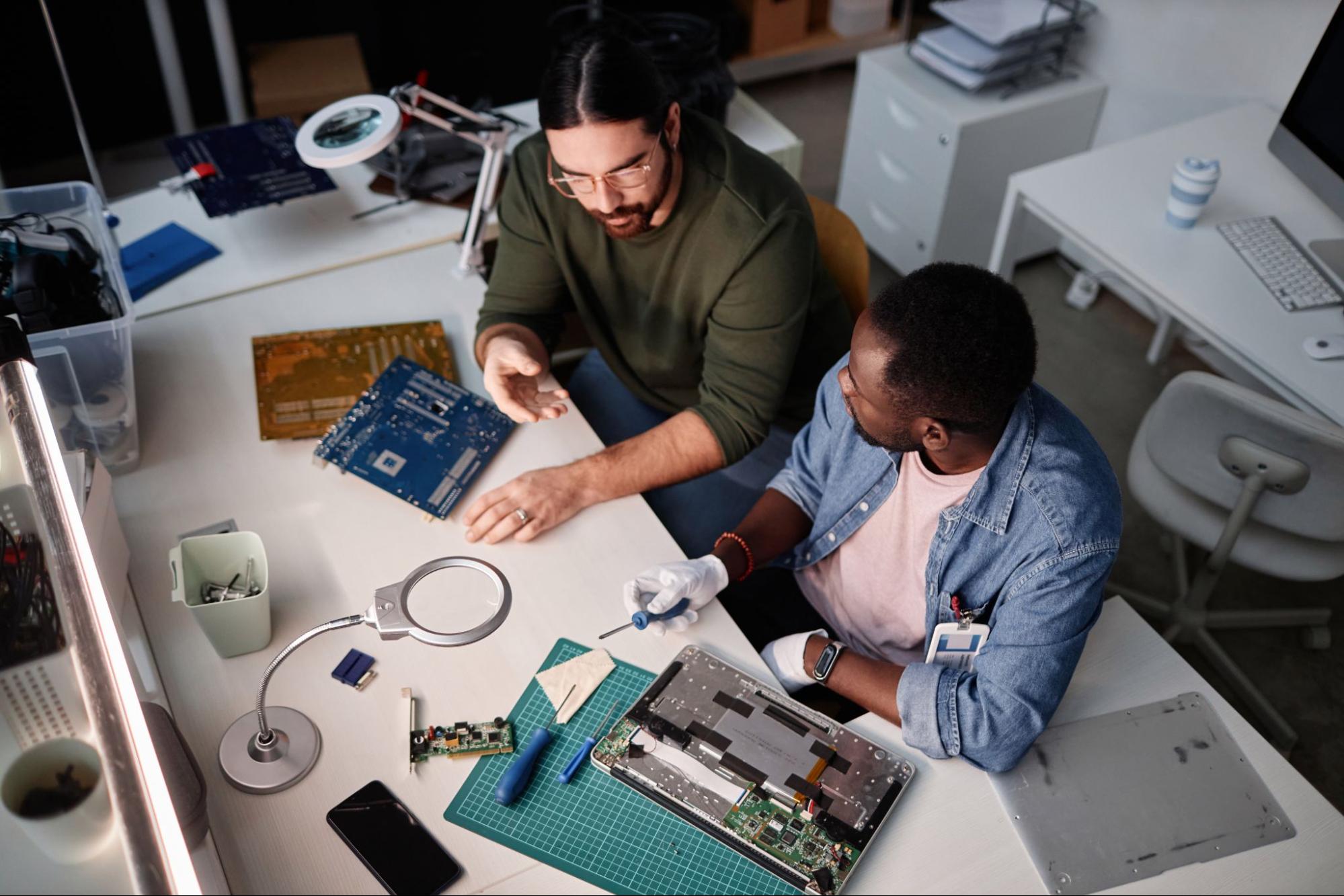 Two experts engaged in a detailed discussion about MacBook battery replacement in Singapore.