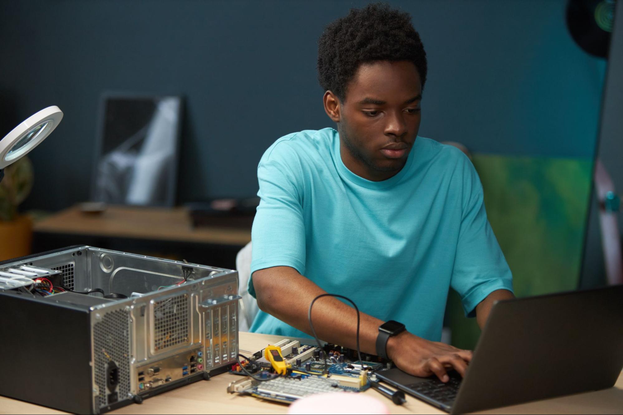 A man carefully repairing a laptop keyboard at the best computer repair service.